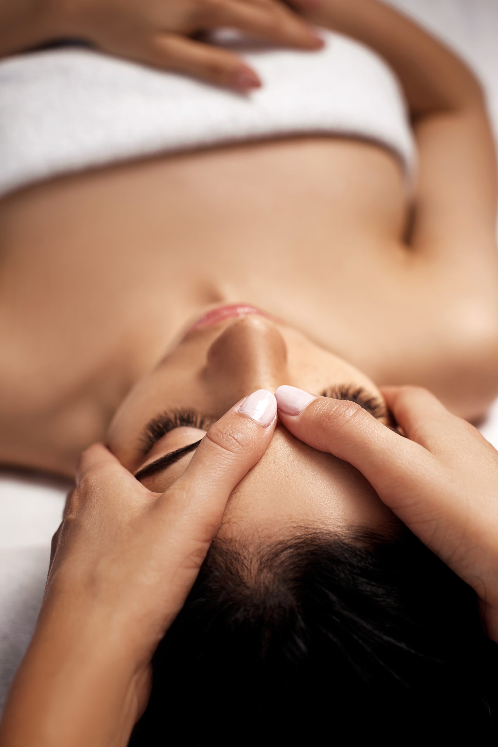 anti-aging facial massage. Woman receiving massage from masseur at Spa salon.