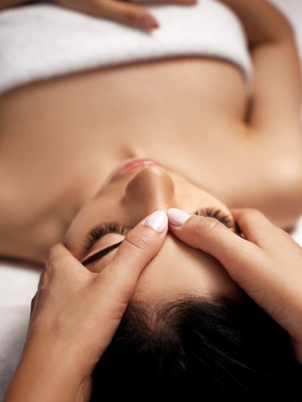 anti-aging facial massage. Woman receiving massage from masseur at Spa salon.